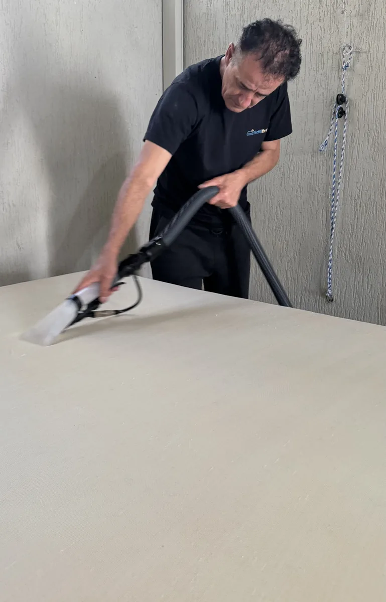 Técnico SofáBrilho com bico extrator sanitizando colchão